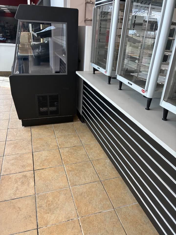 Clean tile floor beside glass food warmers in a convenience store
