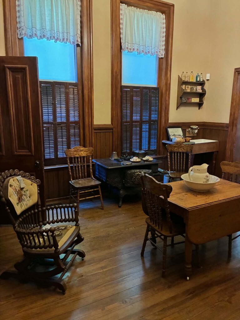 Historic kitchen with a cast-iron stove and wooden chairs at the Vaile Mansion